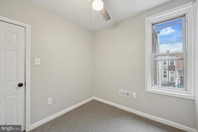 carpeted spare room with ceiling fan