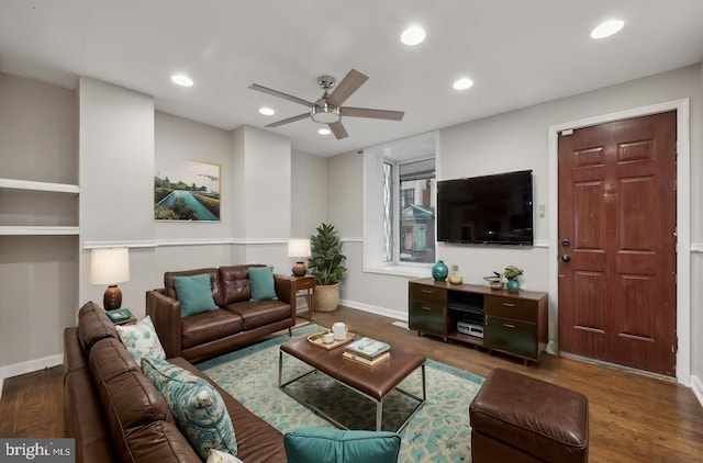 living room featuring ceiling fan and dark hardwood / wood-style floors