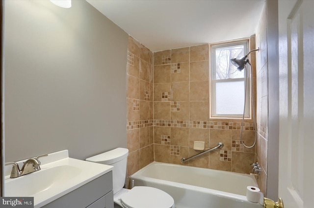 full bathroom featuring tiled shower / bath combo, toilet, and vanity