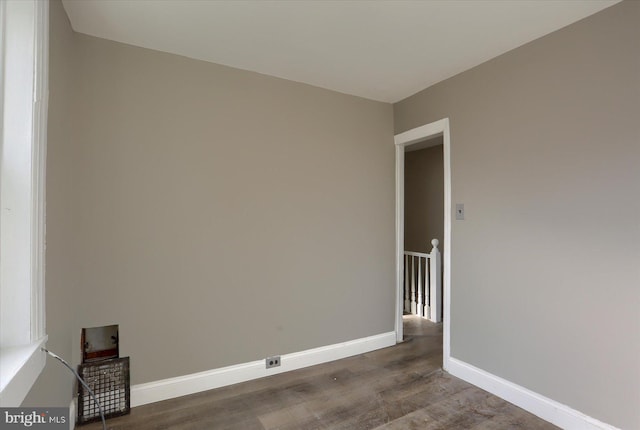 unfurnished room with dark wood-type flooring