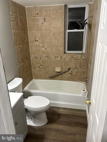 full bathroom with tiled shower / bath, hardwood / wood-style floors, vanity, and toilet