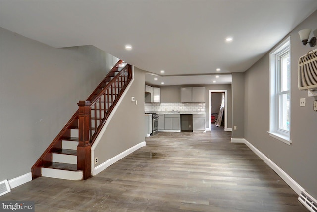 unfurnished living room with dark hardwood / wood-style flooring, a healthy amount of sunlight, and sink