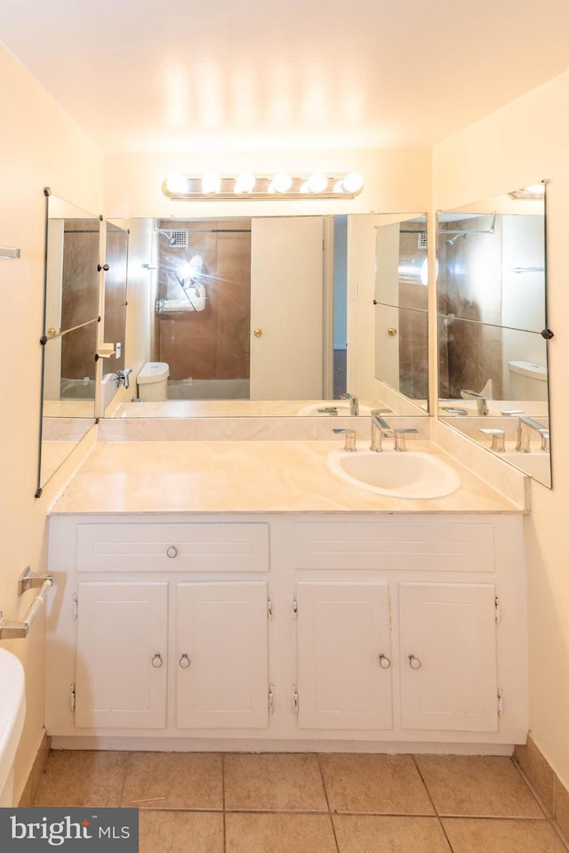 bathroom featuring tile patterned flooring, vanity, and toilet