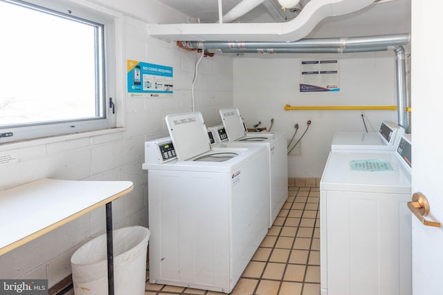 laundry area with washer and clothes dryer and light tile patterned floors