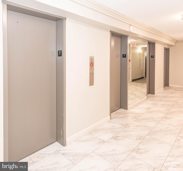 hall with elevator and crown molding