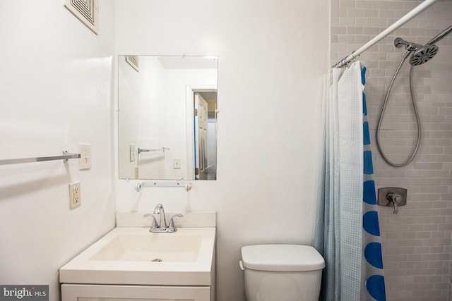 bathroom with a shower with curtain, vanity, and toilet