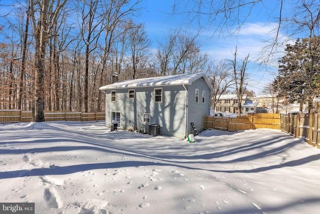 snow covered structure featuring central AC