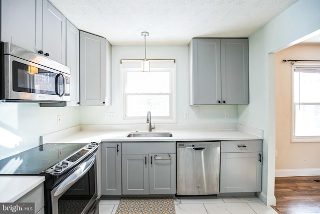 kitchen featuring a textured ceiling, sink, gray cabinetry, and stainless steel appliances