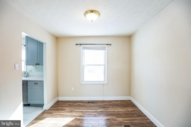 empty room featuring wood-type flooring and a textured ceiling