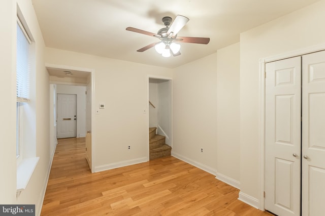 unfurnished bedroom featuring ceiling fan, a closet, and light hardwood / wood-style floors