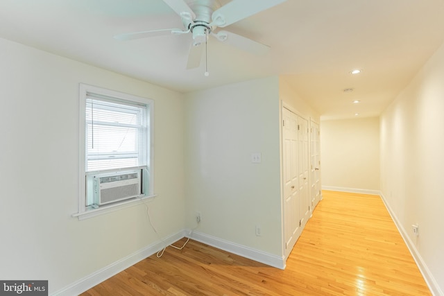 unfurnished room with ceiling fan, cooling unit, and light wood-type flooring