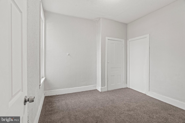 unfurnished bedroom featuring carpet and a textured ceiling