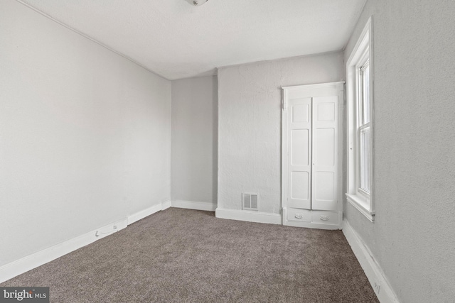 unfurnished bedroom featuring dark carpet