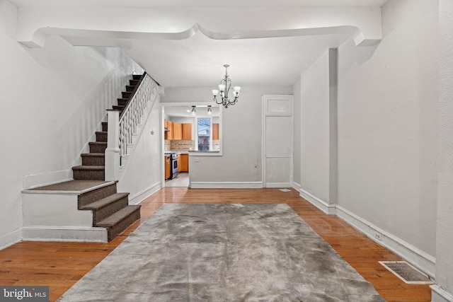 foyer entrance featuring hardwood / wood-style floors and an inviting chandelier