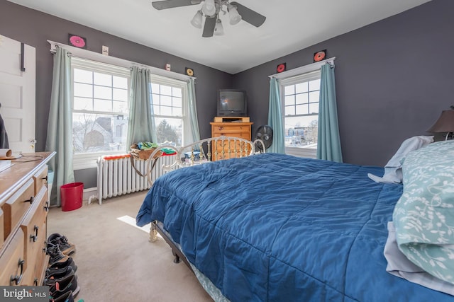 carpeted bedroom with radiator heating unit and ceiling fan