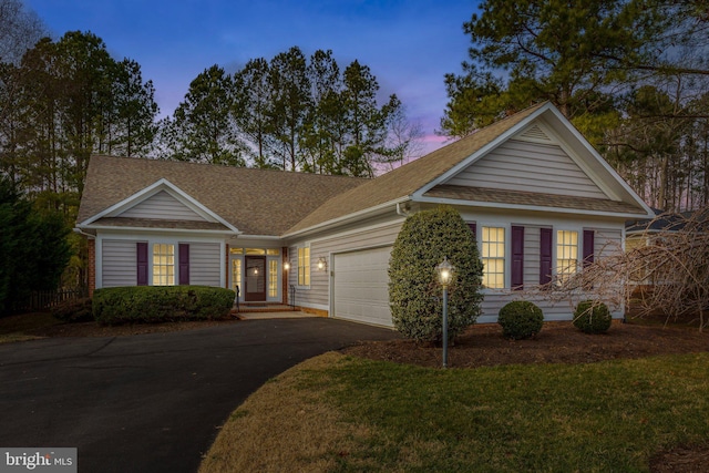 ranch-style house with a yard and a garage