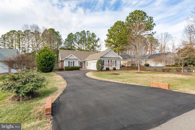 ranch-style house with a garage and a front lawn