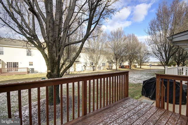 wooden deck with a lawn and central AC unit