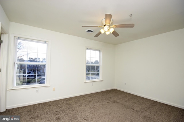 carpeted spare room with ceiling fan