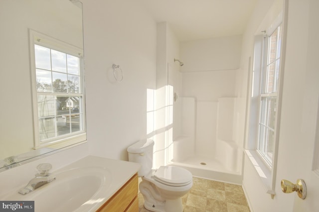 bathroom featuring toilet, vanity, and walk in shower