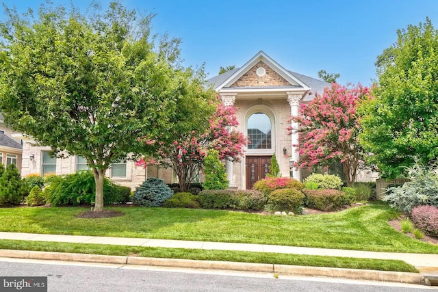 obstructed view of property with a front lawn