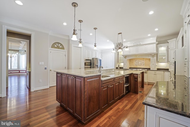 kitchen featuring a large island, dark stone countertops, decorative light fixtures, stainless steel appliances, and dark brown cabinets