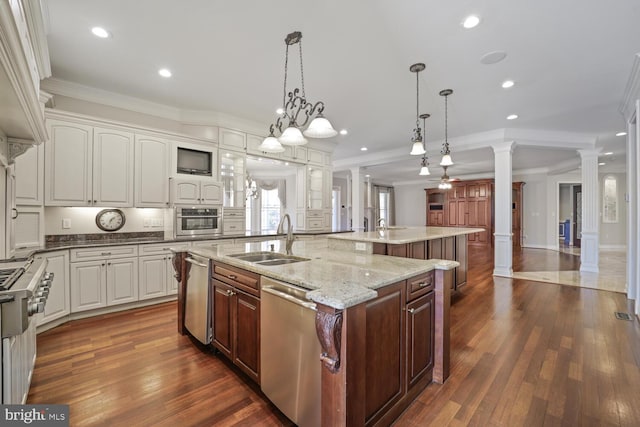 kitchen featuring decorative columns, white cabinets, a spacious island, stainless steel appliances, and pendant lighting