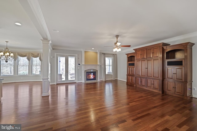 unfurnished living room with dark wood-style floors, a high end fireplace, decorative columns, and baseboards