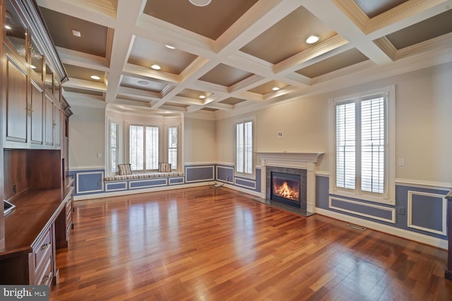 unfurnished living room with crown molding, dark wood-type flooring, beam ceiling, and a high end fireplace