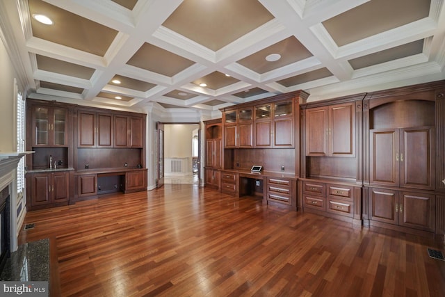 unfurnished living room with beam ceiling, dark wood finished floors, built in study area, a sink, and coffered ceiling