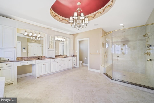 full bathroom with a tray ceiling, a notable chandelier, a shower stall, and toilet