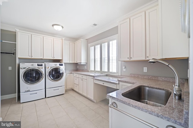 laundry room with washing machine and clothes dryer, cabinet space, visible vents, light tile patterned flooring, and a sink