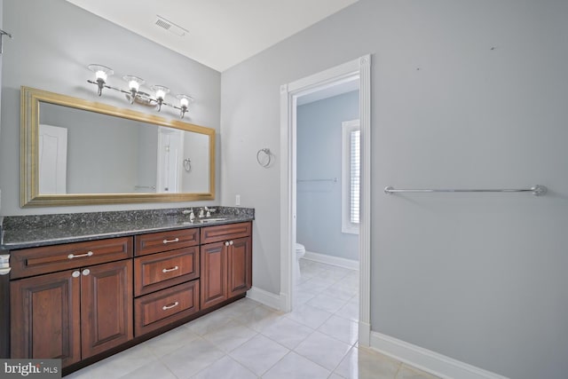 bathroom with baseboards, visible vents, toilet, tile patterned floors, and vanity