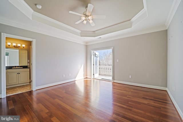 spare room featuring baseboards, a tray ceiling, and wood finished floors