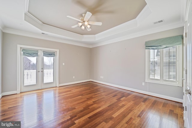 unfurnished room featuring visible vents, a raised ceiling, and a wealth of natural light