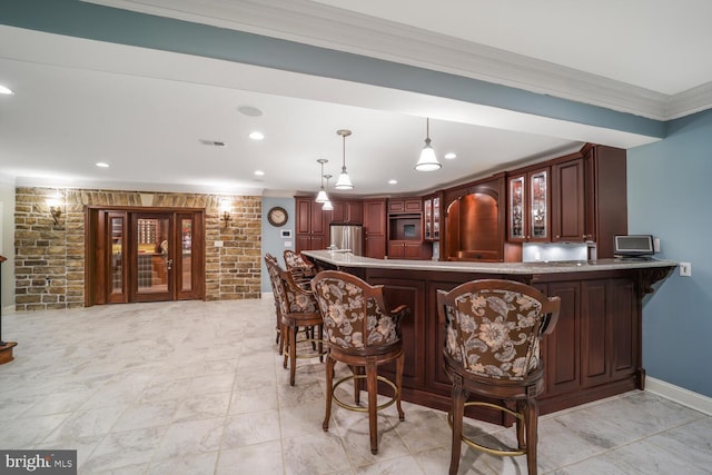 bar featuring indoor wet bar, visible vents, hanging light fixtures, ornamental molding, and freestanding refrigerator