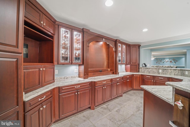 kitchen featuring recessed lighting, glass insert cabinets, and light stone countertops