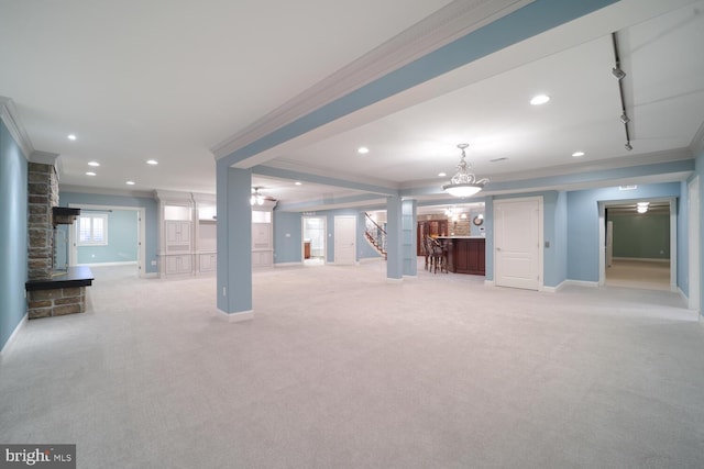 unfurnished living room featuring recessed lighting, light colored carpet, crown molding, and baseboards