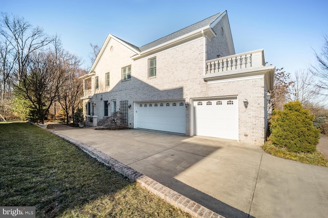 view of property exterior featuring a garage, a balcony, concrete driveway, and a yard