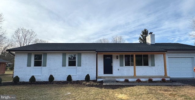 ranch-style house featuring covered porch, a front yard, and a garage