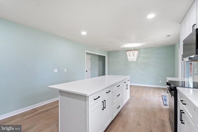 kitchen featuring electric stove, a notable chandelier, white cabinets, a center island, and hanging light fixtures