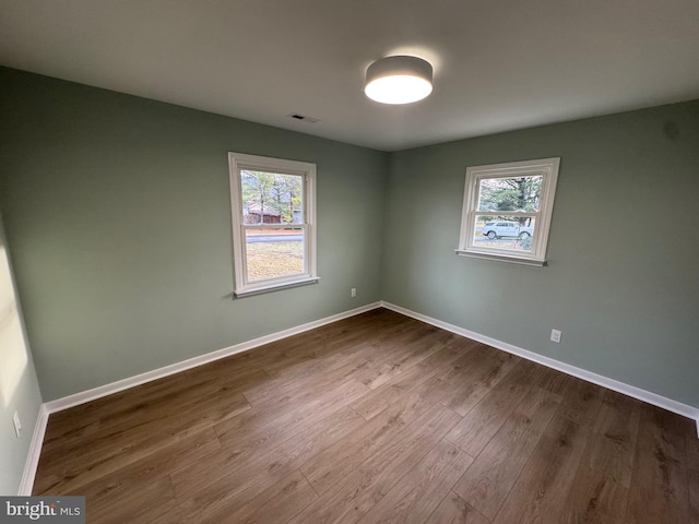 unfurnished room with a healthy amount of sunlight and wood-type flooring