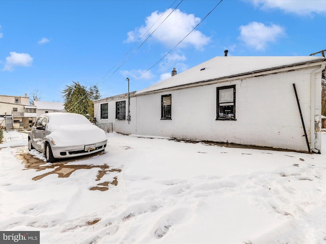 view of snow covered back of property