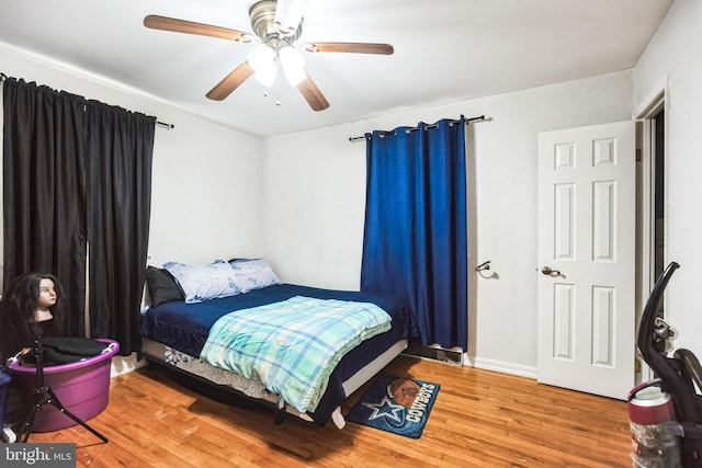 bedroom featuring light wood-style floors, baseboards, and a ceiling fan