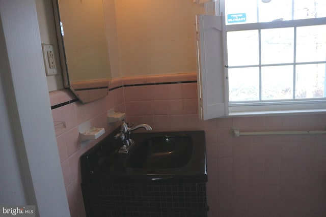 bathroom featuring tile walls and sink