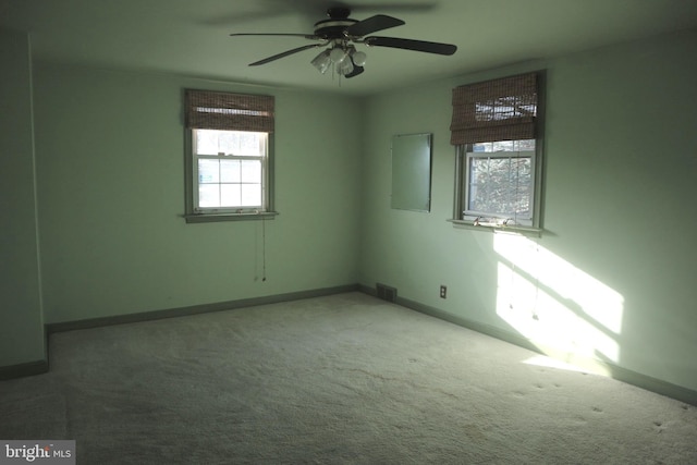 carpeted spare room with a wealth of natural light and ceiling fan