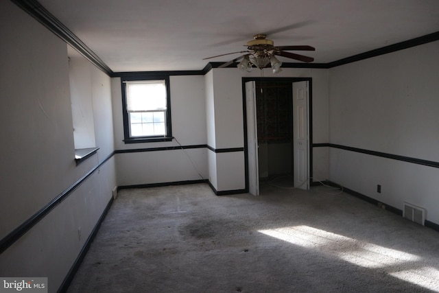 empty room featuring light carpet, ceiling fan, and ornamental molding