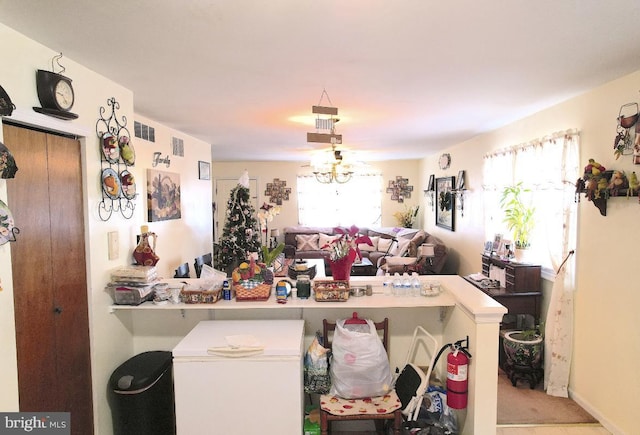 kitchen featuring kitchen peninsula, carpet, refrigerator, and plenty of natural light