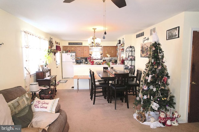 carpeted dining space with ceiling fan