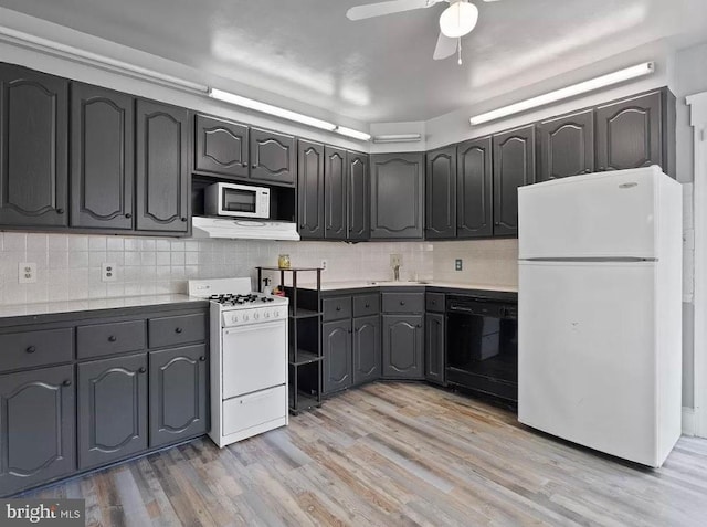 kitchen with white appliances, tasteful backsplash, light hardwood / wood-style flooring, and sink